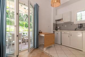 a kitchen with white appliances and a large window at Golden Sun in Parga