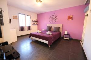 a bedroom with purple walls and a bed with pillows at very pretty contemporary villa with pool located in Aureille in the alpilles, close to the center on foot. sleeps 4. in Aureille +27 photos