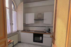 eine Küche mit weißen Schränken und einer Spüle in der Unterkunft Domus Gracchi in Rom