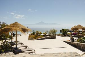 a resort with chairs and umbrellas and the ocean at BANCAL HOTEL and SPA in San Sebastián de la Gomera