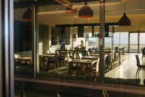 a dining room with tables and chairs and a window at BANCAL HOTEL and SPA in San Sebastián de la Gomera
