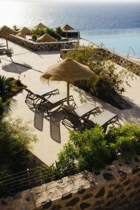a group of chairs and an umbrella on a beach at BANCAL HOTEL and SPA in San Sebastián de la Gomera