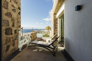 a bench on a balcony with a view of the ocean at BANCAL HOTEL and SPA in San Sebastián de la Gomera