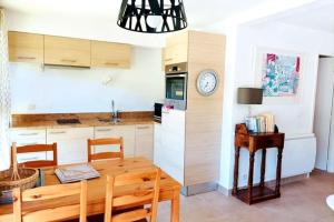 a kitchen and dining room with a table and a clock at Appart T3 avec Terrasse de 60m2 Chalet Le Coucou ALLOS in Allos +20 photos