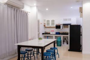 a kitchen with a table and chairs and a refrigerator at City Beach 3 Pool Villa Hua Hin in Hua Hin