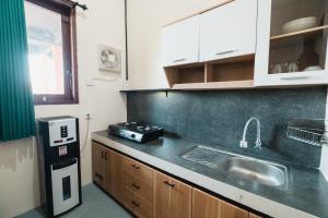 a kitchen with a sink and a refrigerator at Urban Haven Residence in Sanur