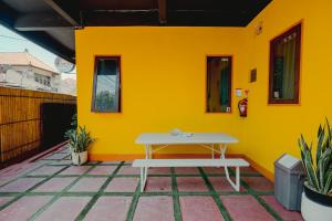 a yellow wall with a white table on a patio at Urban Haven Residence in Sanur +33 photos