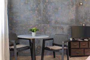 a table with two chairs and a television in a room at Casa Luna in Pozzallo +12 photos