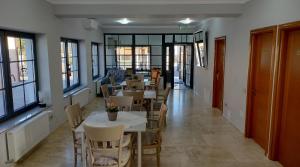 a dining room with tables and chairs and windows at Klok Boutique `Otel in Seini