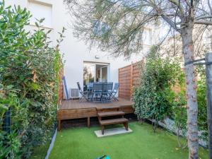 a wooden deck with a table and chairs in a yard at La Dune 38 - Villa 3P6 in Valras-Plage