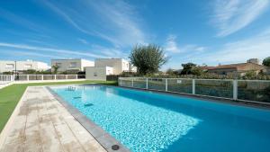 a large swimming pool with blue water in a yard at La Dune 38 - Villa 3P6 in Valras-Plage