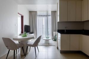 a kitchen with a white table and chairs in a room at Cosy Apartment Marina Gate in Dubai