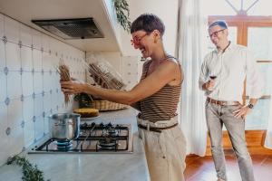 Ein Mann und eine Frau stehen in einer Küche. in der Unterkunft Ginestriccio in Bibbona + 70 Fotos