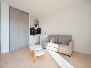 a living room with a couch and a table at La Dune B 203 - ST2 in Valras-Plage