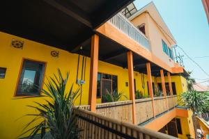 a yellow house with a balcony at Urban Haven Residence in Sanur