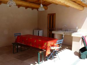 Una cocina con una mesa con sillas y un fregadero. en typical provencal mas with pool, a little corner of paradise with view of sainte victoire, close to aix en provence, sleeps 10., en Venelles