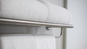 a stack of white towels on a towel rack at Pas Cher Hotel de Bangkok in Bangkok