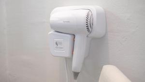a hair dryer is attached to a wall at Pas Cher Hotel de Bangkok in Bangkok