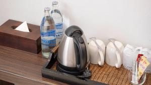 a tea kettle on a counter next to a bottle of water at Pas Cher Hotel de Bangkok in Bangkok