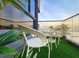 un patio avec une table et des chaises sur un balcon dans l'établissement Loft Suite Seaview 2BR JB CIQ 7Pax, à Johor Bahru