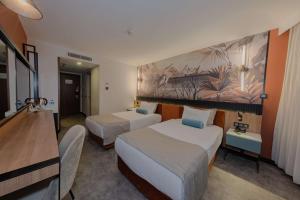 a hotel room with two beds and a desk at Best Western Plus Khan Hotel in Antalya