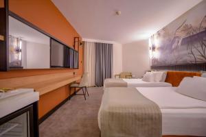 a hotel room with two beds and a desk at Best Western Plus Khan Hotel in Antalya