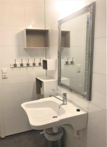 a white bathroom with a sink and a mirror at Saltstraumen camping in Bodø +18 photos