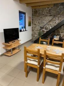 a living room with a wooden table and a television at Ferienwohnung Eschbach Hof am Nürburgring in Herresbach
