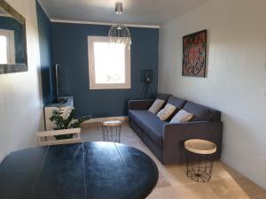 a living room with a couch and a table at Pleasant part of house with pool to share in Vaucluse, 4/6 people in Puget