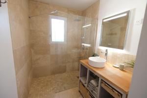 a bathroom with a sink and a shower with a mirror at Pleasant part of house with pool to share in Vaucluse, 4/6 people in Puget