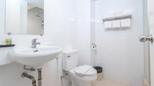 a white bathroom with a sink and a toilet at Pas Cher Hotel de Bangkok in Bangkok