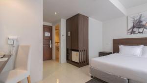 a bedroom with a white bed and a wooden cabinet at Pas Cher Hotel de Bangkok in Bangkok