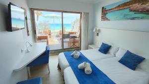 a hotel room with two beds and a couch and a table at BLUESEA Anba Romaní in Cala Millor