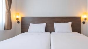two beds in a hotel room with white pillows at Pas Cher Hotel de Bangkok in Bangkok
