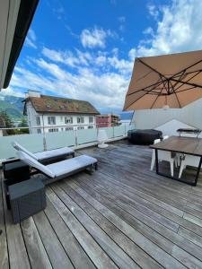 a wooden deck with a table and an umbrella at Appartement Montreux terrasse Lac in Montreux +19 photos