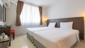 a hotel room with two beds and a window at Pas Cher Hotel de Bangkok in Bangkok