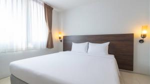 a large white bed in a room with a window at Pas Cher Hotel de Bangkok in Bangkok