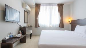 a hotel room with a bed and a window at Pas Cher Hotel de Bangkok in Bangkok