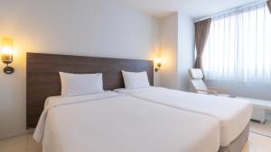 a hotel room with two beds and a window at Pas Cher Hotel de Bangkok in Bangkok
