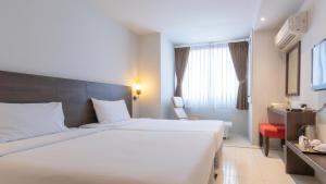 a hotel room with a large white bed and a window at Pas Cher Hotel de Bangkok in Bangkok