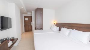 a hotel room with a large bed and a television at Pas Cher Hotel de Bangkok in Bangkok