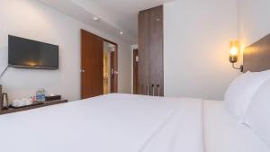 a bedroom with a bed and a tv on the wall at Pas Cher Hotel de Bangkok in Bangkok