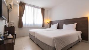 a hotel room with a large bed and a window at Pas Cher Hotel de Bangkok in Bangkok