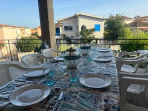 a long table with plates and glasses on a balcony at Sa domo manna in Porto Ottiolu