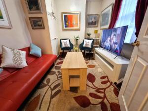 a living room with a red couch and a table at Centrally located in Canterbury with two bedrooms and a sofa bed in Canterbury