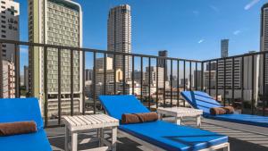 a balcony with blue chairs and a view of the city at Pas Cher Hotel de Bangkok in Bangkok +37 photos