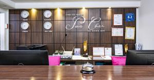 a conference room with clocks on a wooden wall at Pas Cher Hotel de Bangkok in Bangkok
