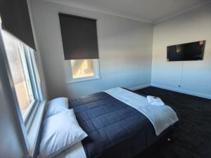 a bedroom with a bed and a flat screen tv at The Club Hotel Collie in Collie