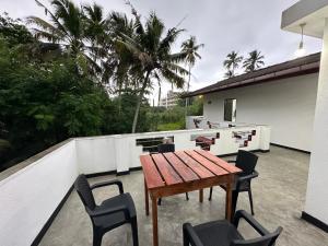un patio con tavolo e sedie in legno su un balcone di Coco Inn Polhena a Matara