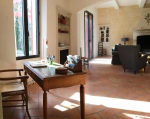 a living room with a table and chairs and a fireplace at beautiful provencal mas with pool in the center of the village of maussane les alpilles – sleeps 14 in Maussane-les-Alpilles